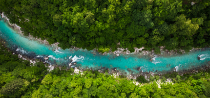Two people seated on stage discussing corporate sustainability, with a large screen displaying the event theme in the background.